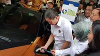 Menteri Energi dan Sumber Daya Mineral (ESDM) Ignasius Jonan mencoba mengisi daya mobil listrik. (Herdi/Liputan6.com)