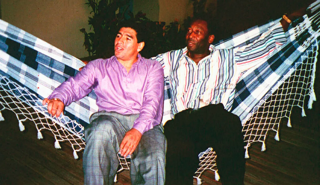 Bintang sepak bola Argentina Diego Armando Maradona (kiri) beristirahat di tempat tidur gantung dengan bintang sepak bola Brasil Edson Arantes do Nascimento atau Pele dalam sebuah pertemuan di Rio de Janeiro, Brasil, 13 Mei 1995. Sepanjang kariernya, Pele juga pernah dinobatkan sebagai Pemain Terbaik Abad 20 oleh FIFA dan mengungguli Diego Armando Maradona. (AP Photo/G. Copolla, File)