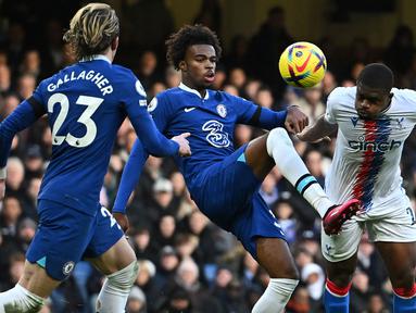 Pemain Chelsea, Carney Chukwuemeka (tengah) berebut bola dengan pemain Crystal Palace, Cheick Doucoure (kanan) pada laga lanjutan Liga Inggris 2022/2023 di Stamford Bridge, London, 15 Januari 2023. Chukwuemeka menjadi salah satu pemain yang dipanggil Timnas Inggris U-20 untuk menjalani laga uji coba menjelang Piala Dunia U-20 2023. Pemain kelahiran Eisenstadt, Austria tersebut telah dipercaya tampil di skuad utama Chelsea sebanyak 12 kali pada musim ini. Ia juga merupakan pemain yang berjasa membawa Inggris lolok ke Piala Dunia U-20 setelah mengantarkan The Young Lions menjuarai Euro U-19. (AFP/Ben Stansall)