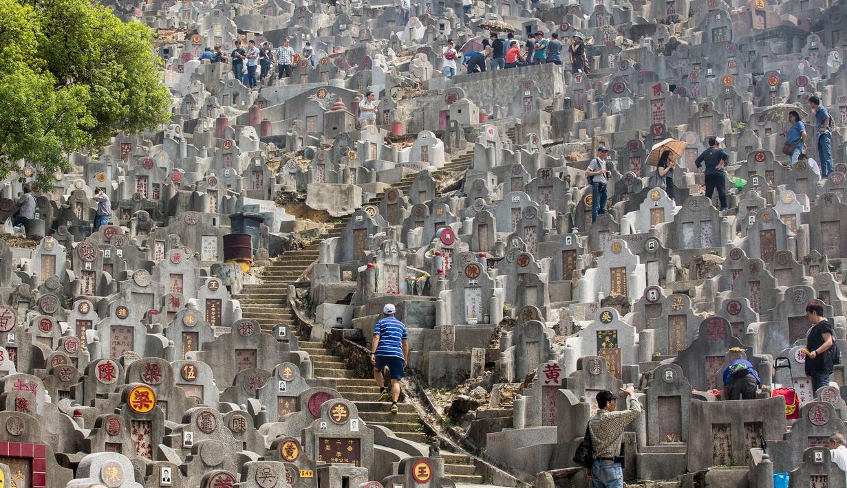 Warga mengunjungi makam keluarga dan kerabat selama festival Qingming di pemakaman di Hong Kong (5/4). Festival Qingming atau dikenal sebagai Hari Pembersihan Makam untuk menghormati orang yang dicintainya yang telah tiada. (AFP Photo/Isaac Lawrence)