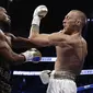 Floyd Mayweather Jr (kiri) melepas pukulan ke Conor McGregor pada pertarungan di T-Mobile Arena in Las Vegas, Nevada, Minggu (27/8/2017). (AP Photo/Isaac Brekken)