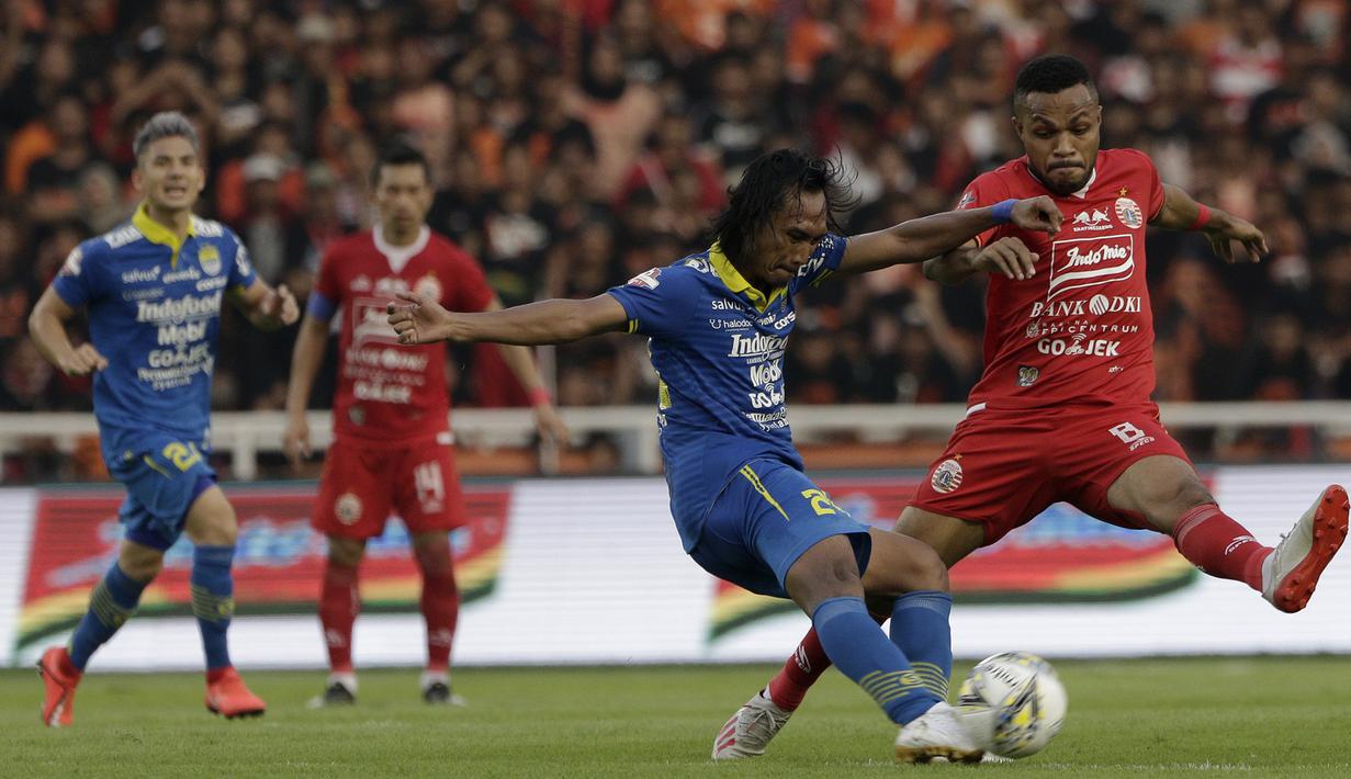 Gelandang Persija Jakarta, Yan Pieter, berebut bola dengan pemain Persib Bandung pada laga Shopee Liga 1 di SUGBK, Jakarta, Rabu (10/7). Persija bermain imbang 1-1 atas Persib. (Bola.com/Yoppy Renato)