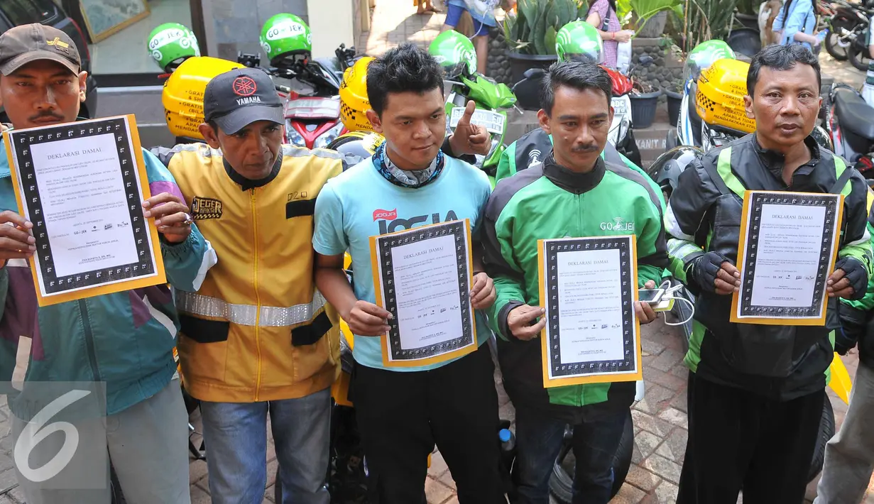 Sejumlah perwakilan pengemudi ojek online dan ojek pangkalan memperlihatkan deklarasi damai komunitas ojek pangkalan dengan komunitas ojek online di Polsek Kebun Jeruk, Jakarta (22/9/2015). (Liputan6.com/Gempur M Surya)