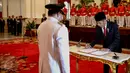 Presiden Joko Widodo (kanan) menandatangani dokumen pelantikan Rano Karno sebagai Gubernur Banten di Istana Negara, Jakarta, Rabu (12/8/2015). Rano menggantikan Ratu Atut yang dipidana dalam kasus korupsi. (Liputan6.com/Faizal Fanani)