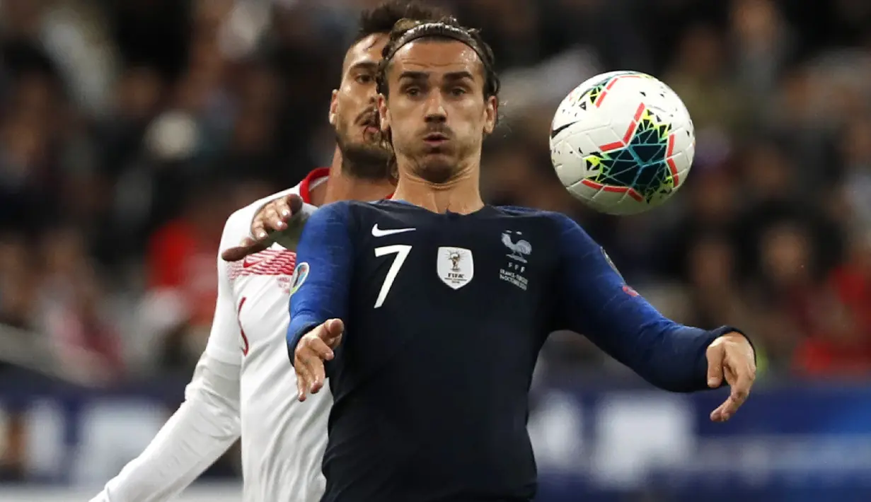 Penyerang Prancis, Antoine Griezmann (depan) berusaha mengontrol bola dari kawalan pemain Turki Okay Yokuslu  selama pertandingan Grup H Kualifikasi Piala Eropa 2020 di Stade de France di Saint Denis, utara Paris (14/10/2019). Turki bermain imbang 1-1 atas Prancis. (AP Photo/Thibault Camus)