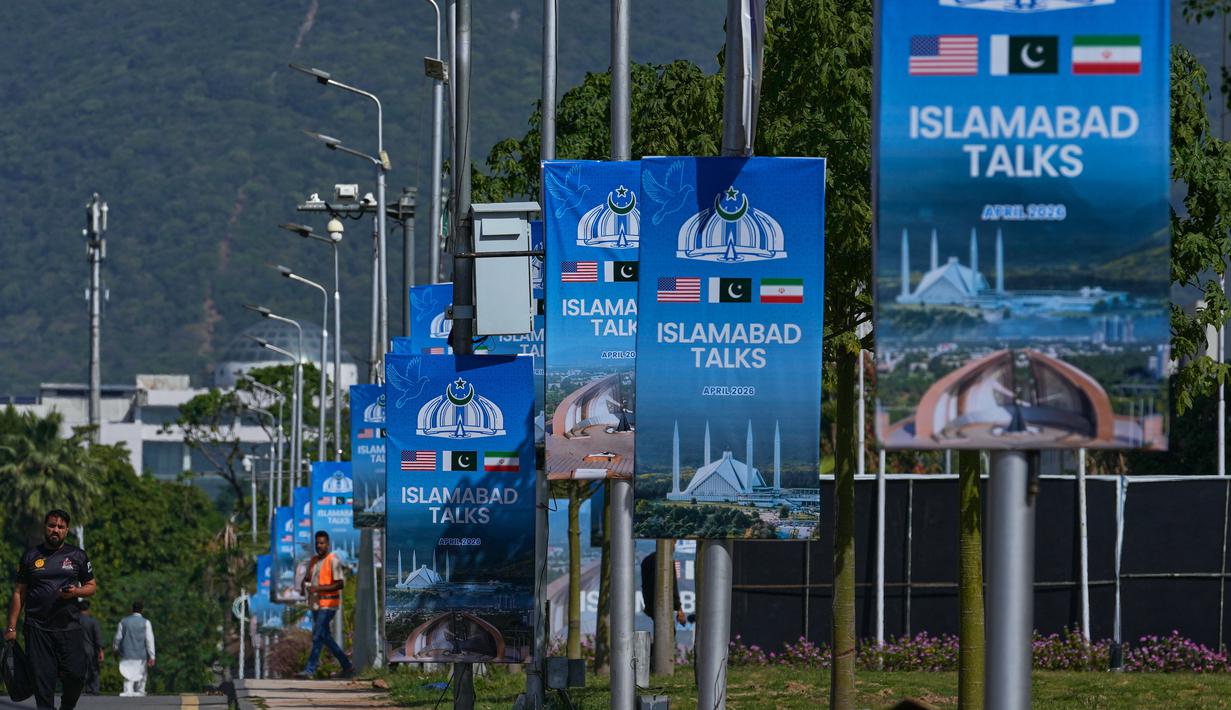 Iran menilai tuntutan Amerika Serikat tidak realistis dan blokade laut masih menghambat negosiasi. Tampak dalam foto, para pekerja berjalan melewati papan reklame di dekat Hotel Serena menjelang putaran kedua negosiasi antara Amerika Serikat dan Iran, di Islamabad, Pakistan, Senin 20 April 2026. (AP Photo/Anjum Naveed)