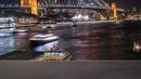 Kombinasi foto ini menunjukkan Sydney Harbour Bridge (bawah) dengan lampunya dimatikan selama kampanye lingkungan Earth Hour dan setelah dinyalakan kembali, di Sydney, Australia pada 25 Maret 2023. (Wendell Teodoro / AFP)