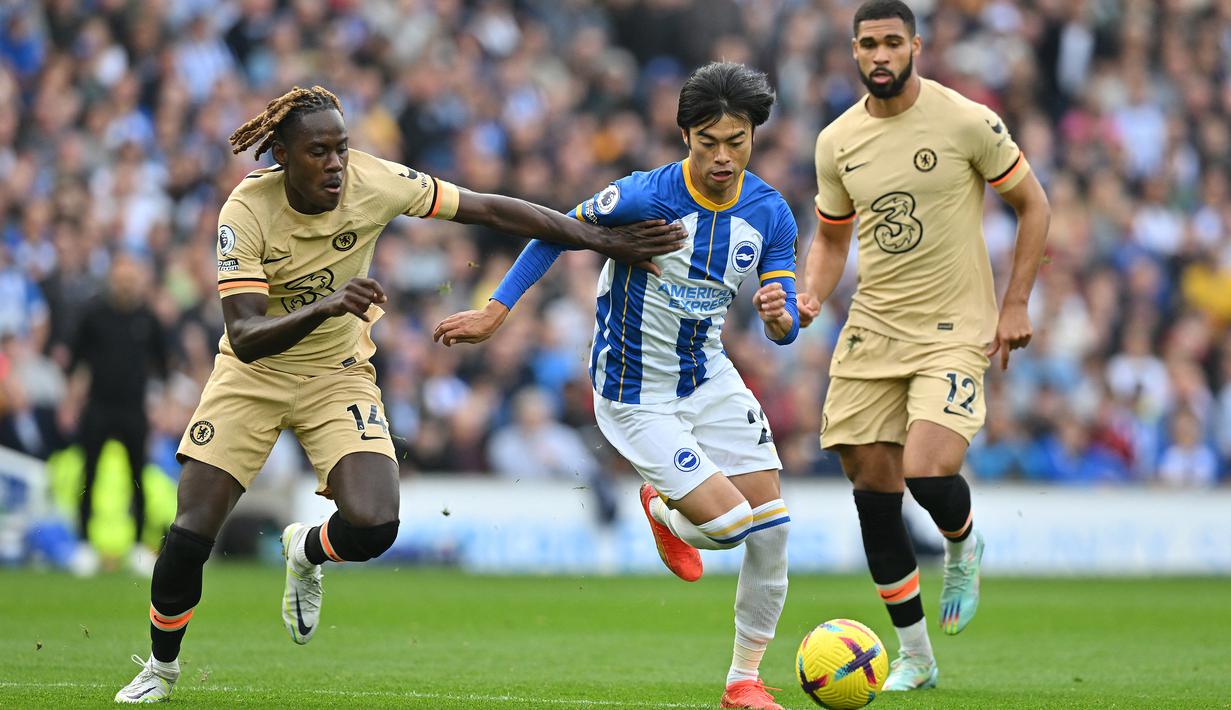 Gelandang Brighton and Hove Albion, Kaoru Mitoma (tengah) menguasai bola dibayangi bek Chelsea, Trevoh Chalobah pada laga Liga Inggris 2022/2023 di Amex Community Stadium, Brighton (29/10/2022). Hingga pekan ke-28 Liga Inggris 2022/2023, Kaoru Mitoma telah mencetak 6 gol dan 4 assist dari total 20 penampilan. (AFP/Glyn Kirk)
