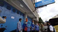 Petugas Dinkes Kota Cirebon menutup toko alkes dari usaha grup apotek Pasuketan karena belasan pegawai farmasi terkonfirmasi positif covid-19. Foto (Liputan6.com / Panji Prayitno)