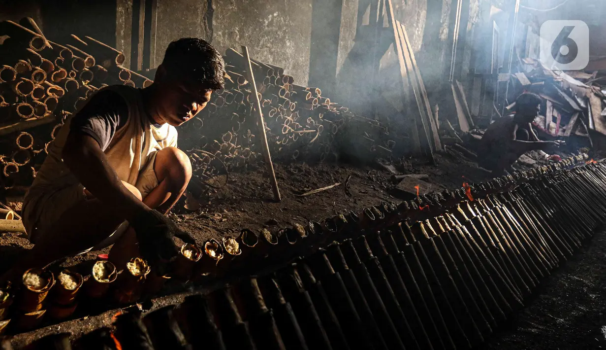 Pekerja melakukan pembakaran lemang bambu di Jalan Kramat Raya, Senen, Jakarta Pusat, Rabu (6/4/2022). Selama Ramadhan, pembuat lemang mampu memproduksi hingga 300 buah dalam sehari, meningkat hingga tiga kali lipat dari hari biasa. (Liputan6.com/Herman Zakharia)