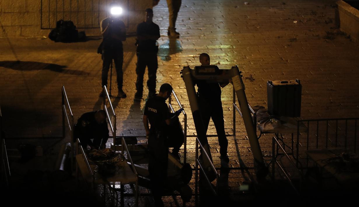 Pasukan keamanan Israel mencopot detektor logam di depan pintu masuk kompleks Masjid Al Aqsa di Kota Tua Yerusalem, Selasa (25/7) dini hari. Israel mengganti detektor logam itu dengan peralatan pengawasan yang tidak begitu mencolok. (Ahmad GHARABLI / AFP)