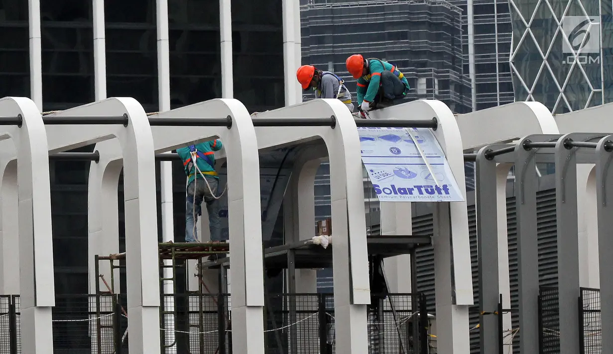 Pekerja melakukan pengerjaan revitalisasi Jembatan Penyeberangan Orang (JPO) Ratu Plaza, Jakarta, Jumat (28/12). JPO Ratu Plaza masuk dalam proses revitalisasi dan ditargetkan selesai pada akhir Desember 2018. (Liputan6.com/JohanTallo)