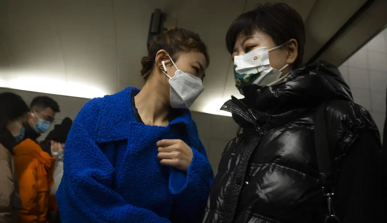 Para komuter yang mengenakan masker untuk melindungi diri dari COVID-19 berjalan melewati stasiun kereta bawah tanah di Beijing, China, Rabu (15/12/2021). China mendeteksi kasus kedua varian omicron pada seorang pria berusia 67 tahun. (AP Photo/Mark Schiefelbein)