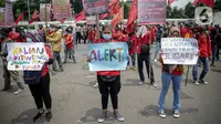Massa buruh membawa poster dan spanduk saat berunjuk rasa di depan Kompleks Gedung DPR/MPR, Jakarta, Selasa (17/11/2020). Buruh kembali menggelar aksi lanjutan menuntut pemerintah dan DPR untuk mencabut Omnibus Law Undang-Undang Cipta Kerja. (Liputan6.com/Faizal Fanani)