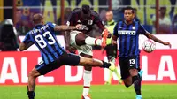 Penyerang AC Milan, Mario Balotelli (tengah) berusaha melewati pemain Inter Milan, Felipe Melo pada lada Derdy della Madonnina, di Stadion Giuseppe Meazza.  (EPA/Matteo Bazzi)