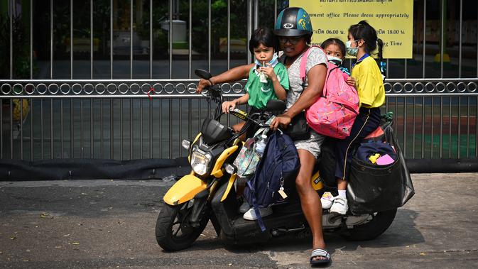 Seorang wanita menjemput anak-anaknya dari sekolah lebih awal karena polusi di Bangkok (30/1). Meningkatnya partikel berbahaya yang dikenal dengan PM 2,5 akhir Desember lalu membuat 437 sekolah di Bangkok tak beroperasi. (AFP Photo/Lillian Suwanrumpha)