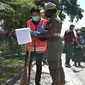 Personel Pol PP Palu saat memberian sanksi membersihkan jalan kepada pelanggar protokol kesehatan di Kota Palu yang terjaring saat operasi yustisi di jalan Mohamad Hatta, Kamis (1/10/2020). (Foto: Liputan6.com/ Heri Susanto).