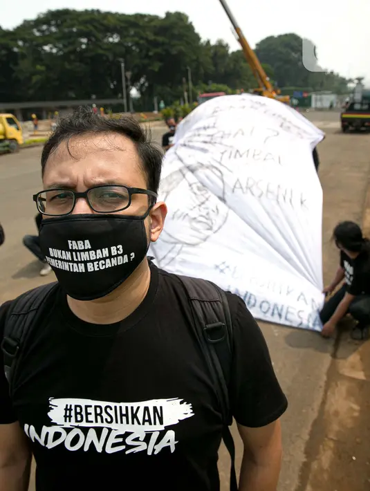 Sejumlah aktivis melakukan aksi simbolik di kawasan Patung Kuda, Jakarta, Kamis (18/3/2021). Aktivis menuntut Presiden Joko Widodo untuk mencabut Omnibus Law UU Cipta Kerja dan regulasi turunannya yang menghapus Fly Ash Bottom Ash (FABA) dari daftar limbah B3. (Liputan6.com/Faizal Fanani)