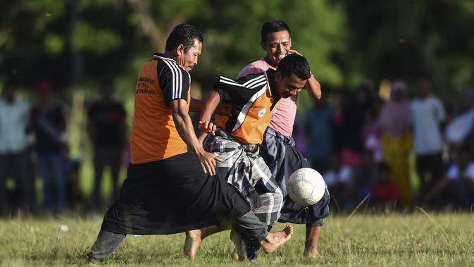 Penduduk desa bermain sepak bola dengan mengenakan sarung saat merayakan HUT ke-74 RI di Blang Pidie provinsi Aceh (17/8/2019). Indonesia merayakan kemerdekaan yang ke-74 dari pemerintahan kolonial Belanda. (AFP Photo/Chaideer Mahyuddin)