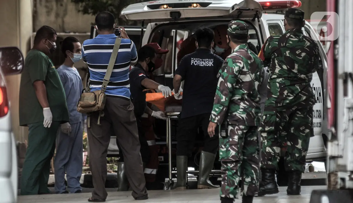 Tim forensik menurunkan kantong jenazah berisi serpihan Sriwijaya Air SJ 182 dan diduga tubuh korban dari ambulans di RS Polri, Jakarta, Minggu (10/1/2021). RS Polri menerima tiga kantong jenazah berisi serpihan pesawat dan diduga tubuh korban untuk diidentifikasi. (merdeka.com/Iqbal S. Nugroho)