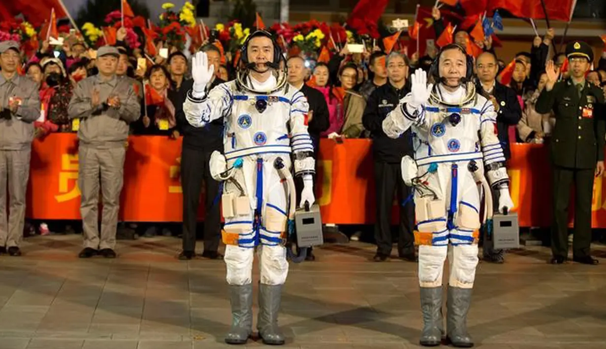 Astronot Tiongkok, Jing Haipeng (kanan), dan Chen Dong, melambaikan tangan sebelum berangkat dengan pesawat ruang angkasa Shenzhou 11 di Jiuquan Satellite Launch Center, Tiongkok, (17/10). (China Daily/via REUTERS)