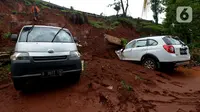 Dua mobil tertimpa longsoran dinding ruas jalan Tol JORR Cikunir, Bekasi, Jawa Barat, Kamis (2/1/2020). Hujan deras pada malam Tahun Baru 2020 membuat sejumlah titik jalan tol rawan longsor dan banjir. (merdeka.com/Imam Buhori)