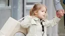 Harper Beckham dan David pergi berbelanja ke toko Bonpoint di London pada 14 Maret 2015. Harper tampil cantik dengan jaket berwarna krem tersebut. (harperbeckhamfashion)