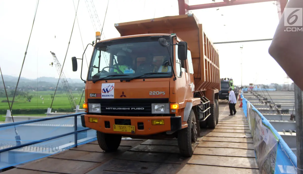 Suasana saat Menteri PUPR Basuki Hadimuljono menaiki truk untuk melintasi Jembatan Kali Kuto di Batang, Jateng, Rabu (13/6). Menurut Hadi, pengoperasian sementara jembatan ini untuk mengurai kepadatan kendaraan pemudik. (Liputan6.com/Arya Manggala)
