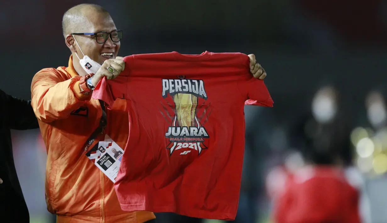 Pelatih Persija Jakarta, Sudirman, melakukan selebrasi dengan menunjukan kaos Persija usai menjuarai Piala Menpora 2021 di Stadion Manahan, Solo, Minggu (25/4/2021). (Bola.com/M Iqbal Ichsan)