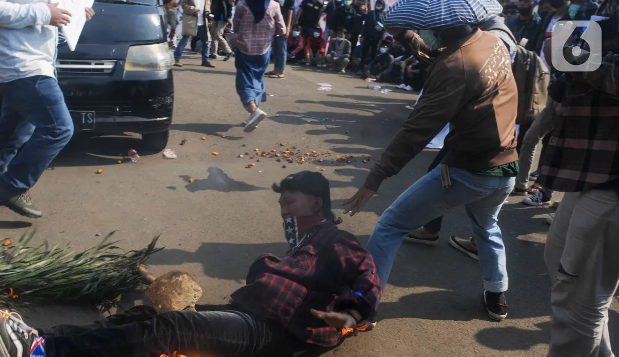 Sejumlah massa yang tergabung dalam Barisan Masyarakat Anti Korupsi, Kolusi dan Nepotisme (BASMI KKN) melakukan aksi teatrikal di kawasan Patung Kuda, Jakarta, Jumat (27/5/2022). Dalam aksi tersebut mereka menuntut pemerintah untuk mengatasi lonjakan harga dan kelangkaan minyak goreng di Indonesia. (Liputan6.com/Herman Zakharia)