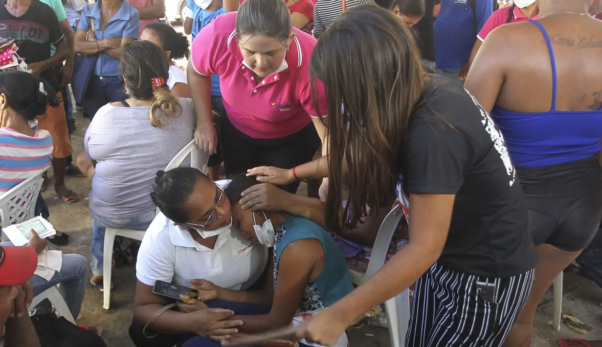 Sejumlah wanita menangis ketika dia menunggu di luar kantor koroner di Altamira, Brasil (30/7/2019). Kerusuhan terjadi saat tahanan geng Comando Classe membakar sel yang berisi tahanan dari geng saingannya, Comando Vermelho, atau Komando Merah. (AP Photo/Raimundo Pacco)