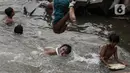 Anak-anak berenang di Sungai Ciliwung, Jakarta, Selasa (24/8/2021). Sungai Ciliwung menjadi tempat alternatif untuk bermain di kala pandemi karena ditutupnya ruang-ruang bermain atau taman kota, dan juga karena kurangnya ruang bermain bagi anak-anak. (Liputan6.com/Johan Tallo)