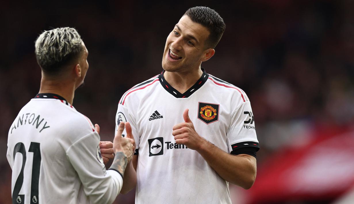 Pemain Manchester United, Diogo Dalot merayakan gol kedua tim bersama rekannya, Antony saat laga lanjutan Liga Inggris 2022/2023 melawan Nottingham Forest di City Ground, Nottingham, Senin (17/04/2023) WIB. Ini merupakan gol perdana Dalot di Liga Inggris. (AFP/Darren Stapels)