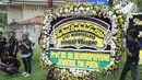 Seorang pria meletakkan karangan bunga duka cita di dekat kediaman Bondan Winarno di kawasan Sentul, Bogor, Rabu (29/11). Tahun ini Bondan telah menjalani dua kali operasi jantung sebelum akhirnya meninggal dunia pagi tadi. (Liputan6.com/Herman Zakharia)