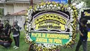 Seorang pria meletakkan karangan bunga duka cita di dekat kediaman Bondan Winarno di kawasan Sentul, Bogor, Rabu (29/11). Tahun ini Bondan telah menjalani dua kali operasi jantung sebelum akhirnya meninggal dunia pagi tadi. (Liputan6.com/Herman Zakharia)
