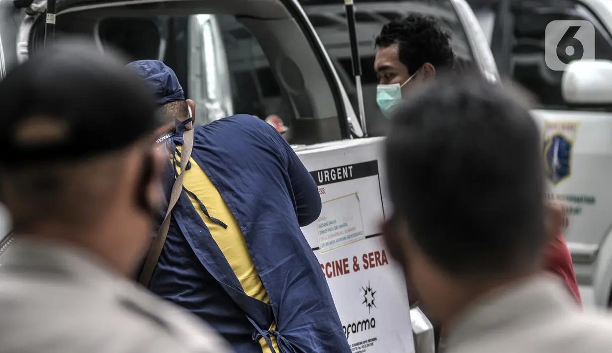 Petugas memasukkan dus berisi vaksin COVID-19 produksi Sinovac ke dalam ambulans puskesmas di Gedung Dinas Kesehatan DKI Jakarta, Rabu (13/1/2021). Pendistribusian vaksin COVID-19 dilakukan jelang penyuntikan yang akan diprioritaskan untuk tenaga kesehatan. (merdeka.com/Iqbal S. Nugroho)