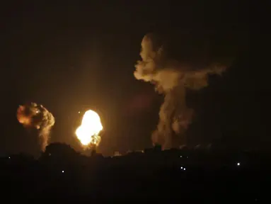 Asap dan bola api membubung menyusul serangan udara di Khan Yunis, Jalur Gaza, Minggu (2/1/2022). Israel melancarkan serangan udara terhadap Gaza. (SAID KHATIB/AFP)