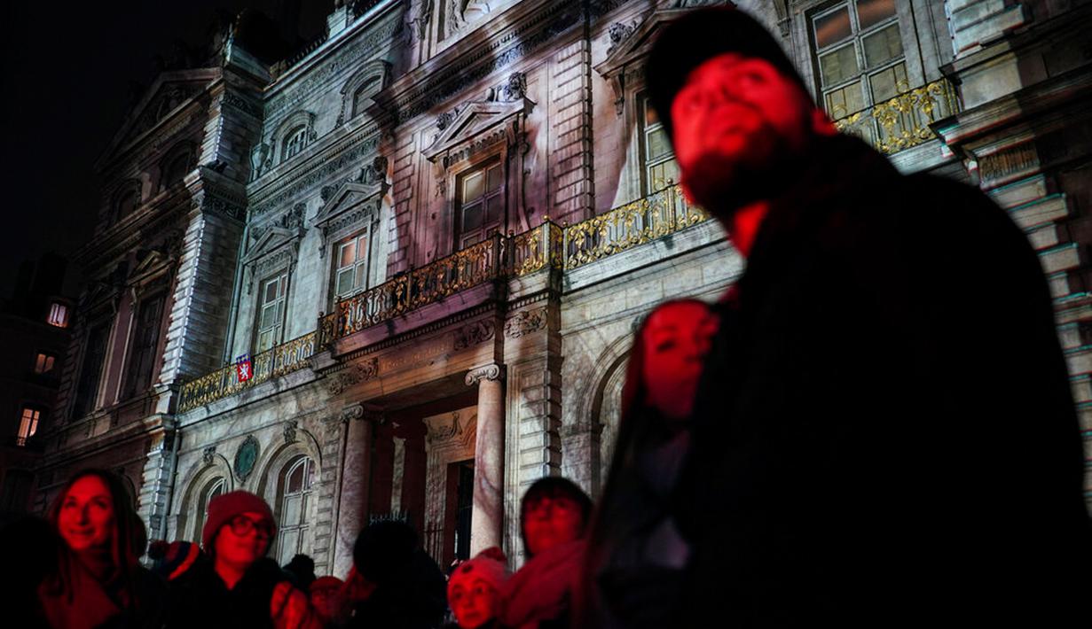 Orang-orang menghadiri pertunjukan cahaya malam di Lyon, Prancis, 8 Desember 2022. Jutaan orang diperkirakan akan menyaksikan acara Festival Cahaya selama empat hari di kota tersebut. (AP Photo/Laurent Cipriani)