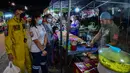 <p>Penjual membuat makanan untuk pembeli  selama bulan suci Ramadhan di pasar malam di provinsi Narathiwat, Thailand selatan (21/4/2022). Penjual makanan jalanan mendirikan kios mereka untuk menjual makanan kepada umat Muslim untuk berbuka puasa. (AFP/Madaree Tohlala)</p>