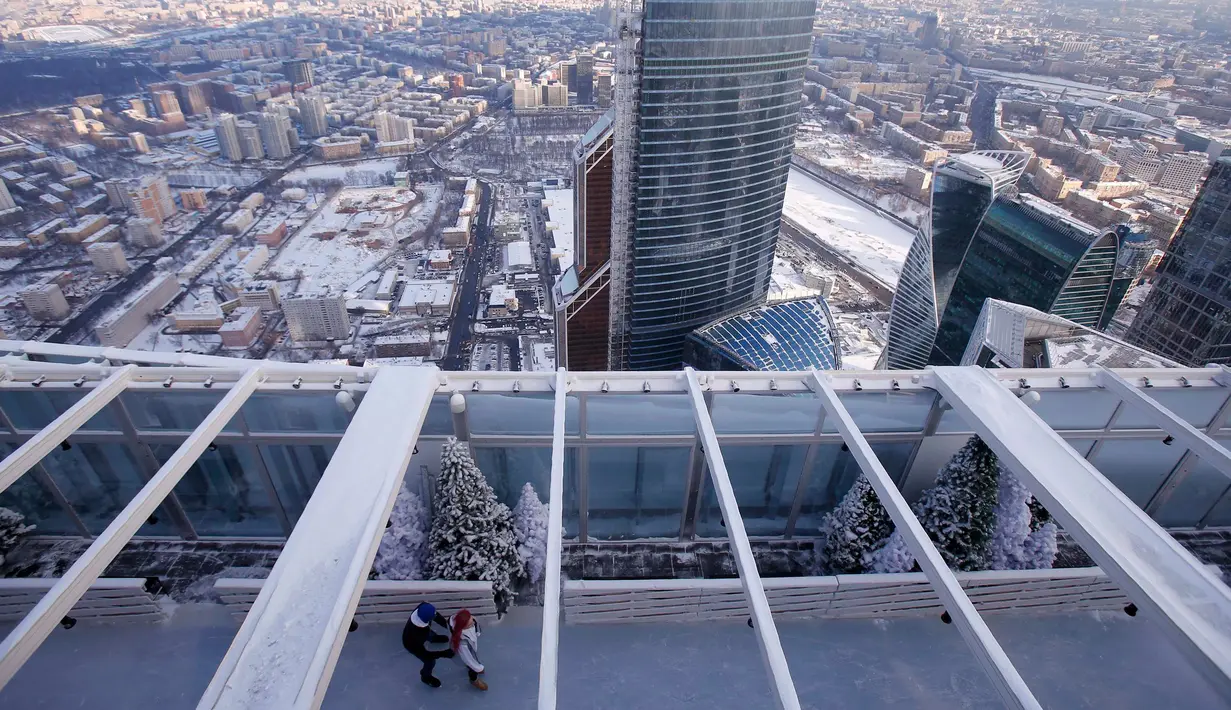Pengunjung menikmati kebersamaan dengan bermain ice skating di arena ski lantai teratas pusat bisnis Oko Tower di Moskow, Kamis (15/12). Arena ski yang berada di ketinggian 354 meter ini diklaim menjadi yang tertinggi di Eropa. (REUTERS/Maxim Shemetov)