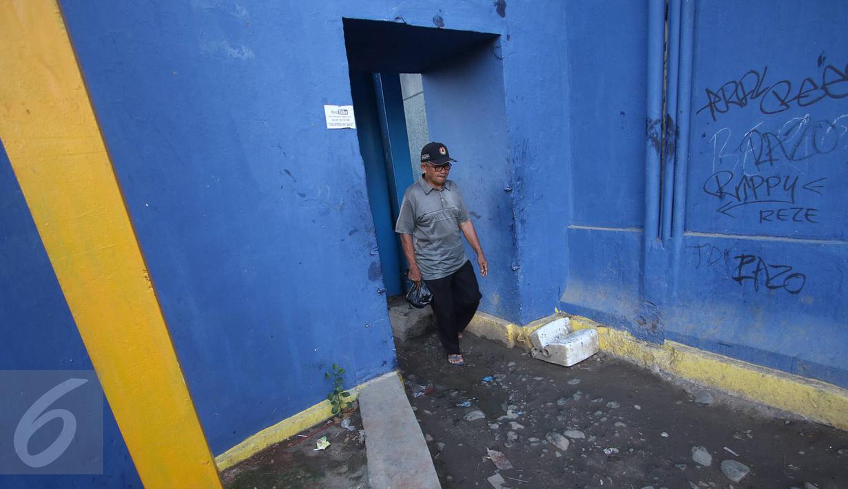 Tidak tersedianya jembatan penyeberangan orang menyebabkan warga harus melintasi jalan setapak di pintu air Petamburan untuk menyeberangi aliran Kanal Banjir Barat (KBB), Jakarta, Jumat (17/2). (Liputan6.com/Immanuel Antonius)