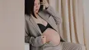 Greysia tak ragu pamer baby bump di trimester ketiga kehamilan mengenakan blazer warna mocca dan bra hitam. [Foto: cr/@bennylims/@juniapics].