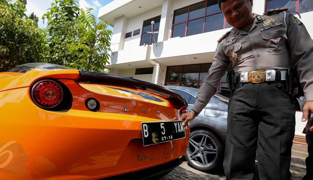 Petugas menunjukan mobil mewah berplat nomor palsu di Kantor Satlantas Jakarta Utara, Kamis (28/5/2015). Satlantas Jakarta Utara berhasil mengamankan beberapa unit mobil mewah yang diduga bodong. (Liputan6.com/Faizal Fanani)