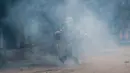 Petugas menendang gas air mata saat demo yang berlangsung ricuh di Srinagar, Kashmir, India, Jumat (3/2). Demonstran memprotes hukuman mati yang diberikan oleh pengadilan Kolkata terhadap seorang pria Kashmir bernama Muzaffar Ahmed. (AP Photo/Dar Yasin)