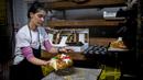 Seorang tukang roti membuat Bolo Rei atau Kue Raja di toko roti Padaria da Ne, Amadora, Portugal, 16 Desember 2022. Bolo Rei disebut sebagai Kue Raja karena bahan-bahan yang dibutuhkan untuk membuat kue ini cukup mahal. (CARLOS COSTA/AFP)