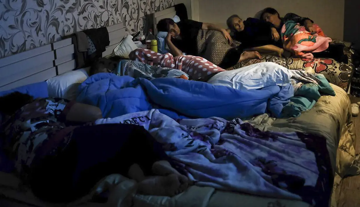 Warga menonton TV Negara saat berkumpul dalam tempat penampungan untuk melindungi diri dari serangan bom di Stepanakert, Republik Nagorno-Karabakh, Azerbaijan, 28 September 2020. Serangan antara Armenia dan Azerbaijan menewaskan puluhan orang. (Armenian Foreign Ministry via AP)