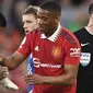 Pemain MU, Anthony Martial (kanan), mengambil sepatu miliknya dari tangan pemain Chelsea, Enzo Fernandez, dalam laga tunda pekan ke-32 Liga Inggris 2022/2023 yang berlangsung di Old Trafford, Jumat (26/5/2023). (AFP/Oli Scarff)