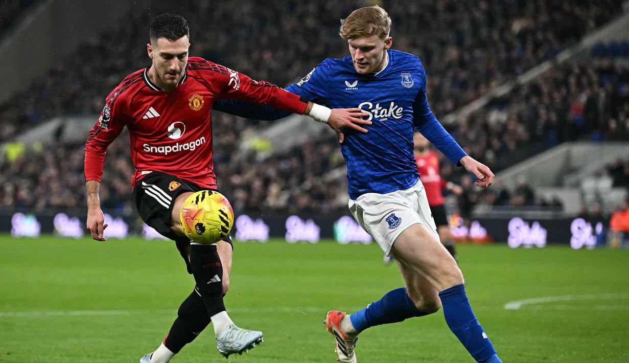 Memasuki babak kedua, Everton langsung mengambil inisiatif serangan lebih dulu. Namun Manchester United mampu mengimbangi permainan dan kembali mengontrol jalannya laga. Tampak dalam foto, bek Manchester United asal Portugal, Diogo Dalot (kiri) menahan bek Everton asal Inggris, Jarrad Branthwaite, selama pertandingan pekan ke-27 Liga Primer Inggris 2025/2026 di Stadion Hill Dickinson, Liverpool, barat laut Inggris, Senin 23 Februari 2026 waktu setempat atau Selasa 24 Februari 2026 dini hari WIB. (Paul ELLIS/AFP)