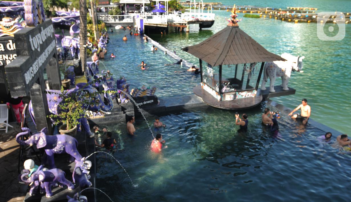 <p>Sejumlah wisatawan berendam di kolam air panas yang terletak di pinggir Danau Batur, Kintamani, Bangli, Bali, Rabu (04/03/20222). Kunjungan wisatawan domestik (Wisdom) ke Pulau Bali saat libur Lebaran 2022 terus meningkat. Per hari kedatangan wisdom rata-rata 40 ribu, dibandingkan sebelum lebaran berkisar 20 ribu per hari. (merdeka.com/Arie Basuki)</p>