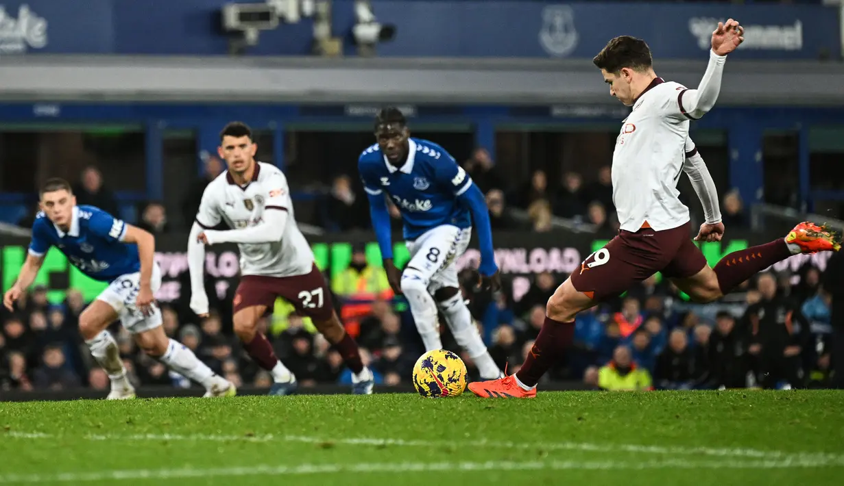 Pemain Manchester City, Julian Alvarez (kanan) mencetak gol melalui tendangan penalti pada laga lanjutan Liga Inggris 2023/2024 melawan Everton di Goodison Park, Liverpool, Inggris, Kamis (28/12/2023) dini hari WIB. (AFP/Paul Ellis)